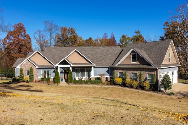 craftsman inspired home featuring a garage and a front lawn