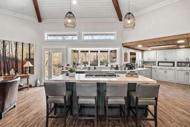 kitchen featuring beamed ceiling, wood ceiling, and decorative light fixtures