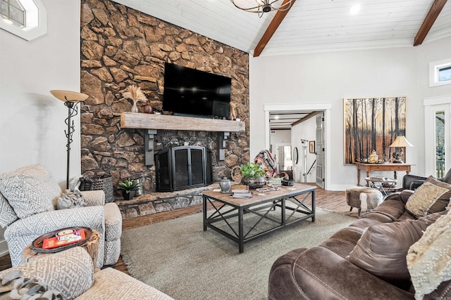 living room with hardwood / wood-style flooring, a stone fireplace, wooden ceiling, and lofted ceiling with beams