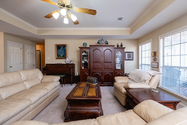 living room with ceiling fan, ornamental molding, and a tray ceiling