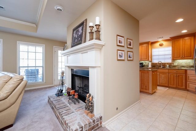 interior space with sink, crown molding, decorative backsplash, light colored carpet, and dark stone counters