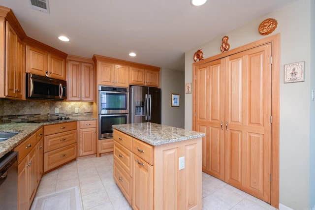 kitchen with light tile patterned floors, stainless steel appliances, light stone counters, a kitchen island, and decorative backsplash