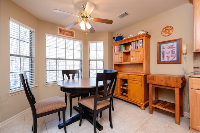 tiled dining area with ceiling fan