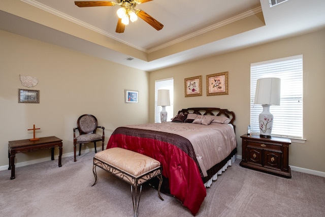 bedroom with ornamental molding, light carpet, and a tray ceiling