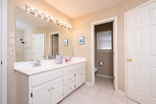 bathroom featuring vanity, tile patterned floors, and toilet