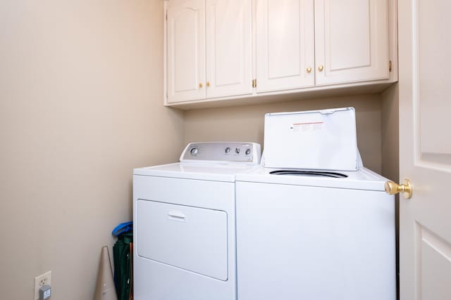 washroom featuring washer and clothes dryer and cabinets