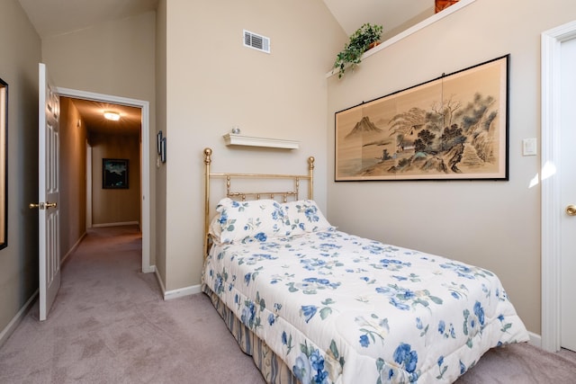 bedroom with vaulted ceiling and light carpet