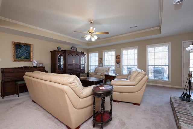 carpeted living room featuring a raised ceiling, ornamental molding, and ceiling fan