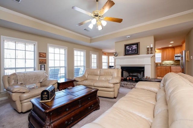 living room with a wealth of natural light, ornamental molding, light carpet, and a fireplace