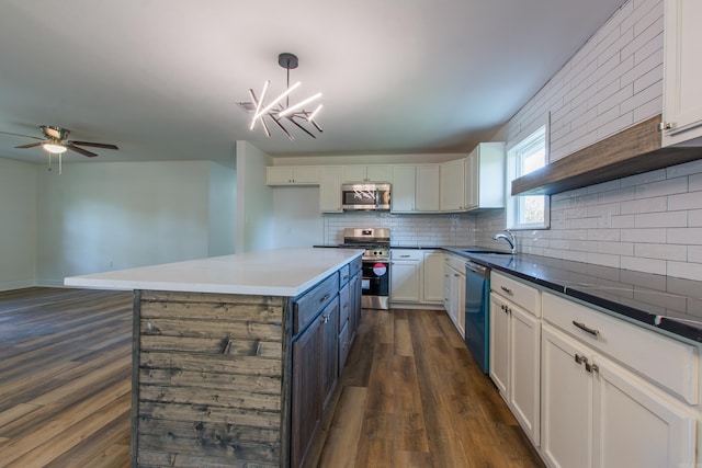 kitchen with decorative light fixtures, white cabinetry, sink, decorative backsplash, and stainless steel appliances