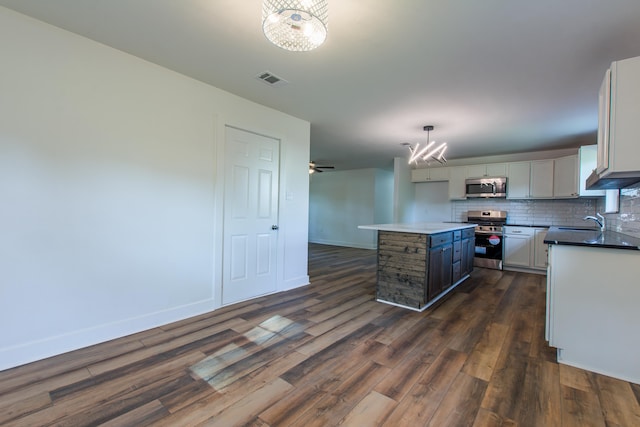 kitchen with a kitchen island, pendant lighting, tasteful backsplash, sink, and stainless steel appliances