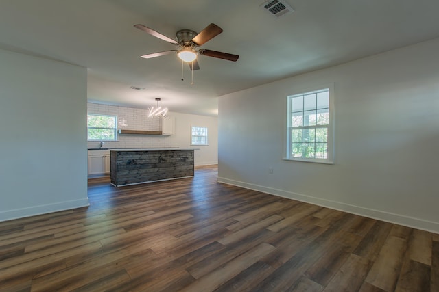 unfurnished living room with ceiling fan and dark hardwood / wood-style flooring