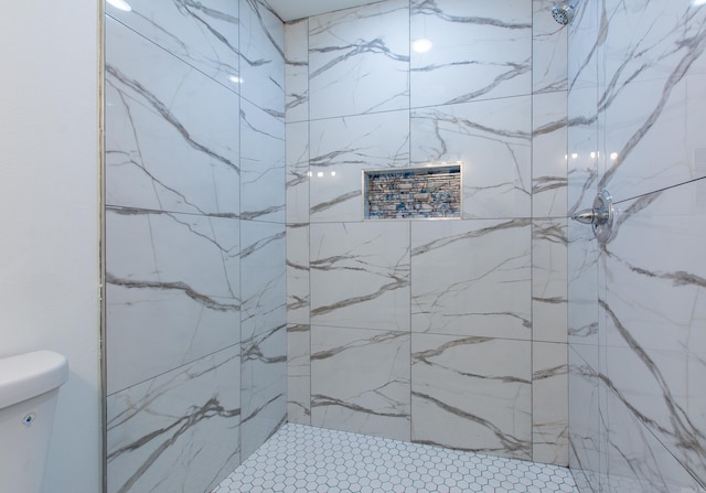 bathroom with tiled shower and toilet