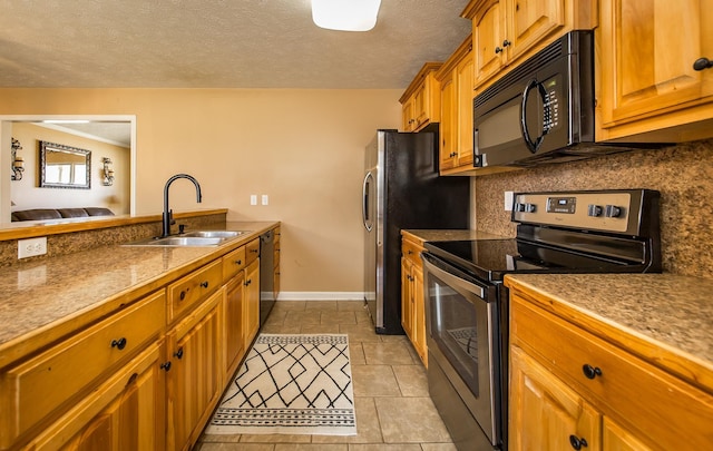 kitchen with light tile patterned flooring, sink, backsplash, black appliances, and a textured ceiling