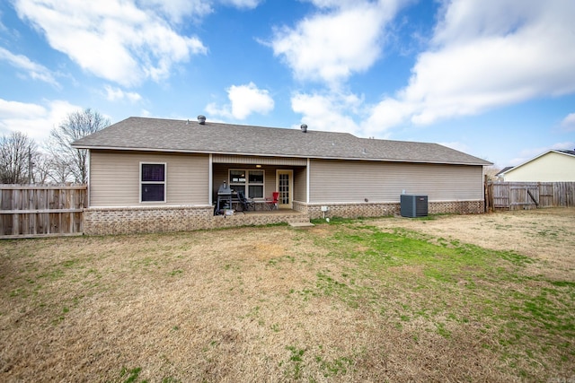 back of property with a patio, a lawn, and central air condition unit