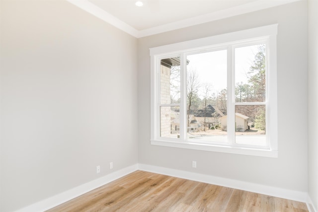 unfurnished room featuring ornamental molding and light wood-type flooring