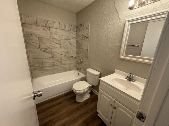 full bathroom featuring hardwood / wood-style flooring, vanity, toilet, and tiled shower / bath