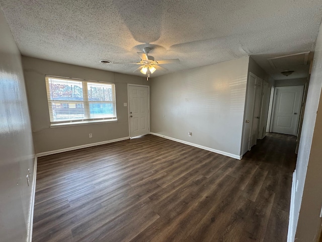 unfurnished room with ceiling fan, dark hardwood / wood-style floors, and a textured ceiling