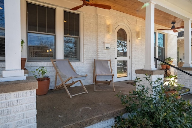 view of exterior entry with ceiling fan and a porch