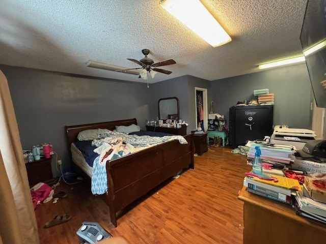 bedroom featuring hardwood / wood-style flooring, ceiling fan, and a textured ceiling