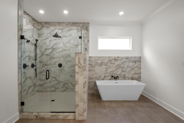 bathroom featuring tile walls, ornamental molding, and plus walk in shower