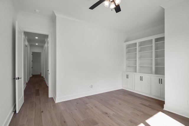 spare room with ornamental molding, ceiling fan, and light wood-type flooring