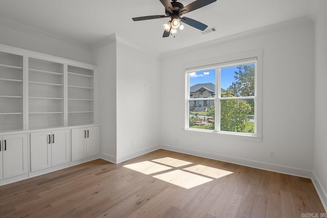 empty room featuring crown molding, ceiling fan, and light wood-type flooring