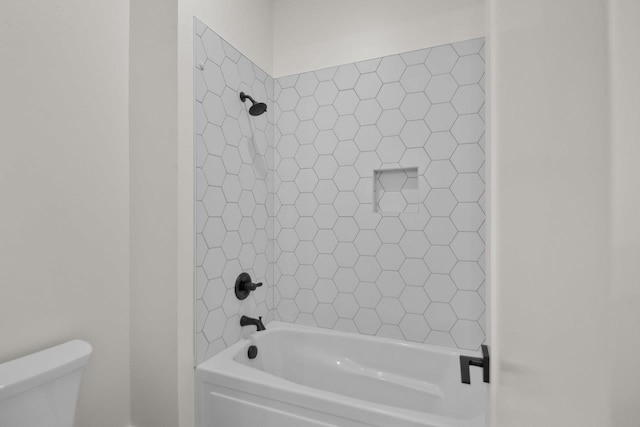 bathroom with tiled shower / bath combo and toilet