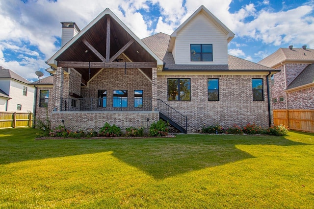 rear view of house featuring a yard