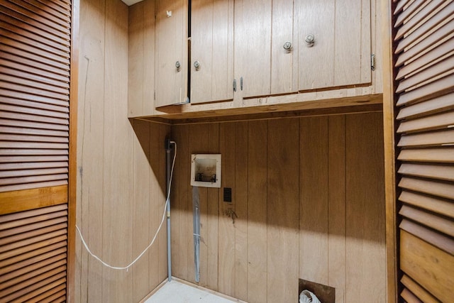 laundry area with cabinets, wooden walls, and hookup for a washing machine