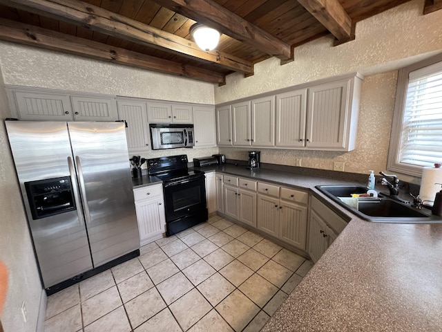 kitchen featuring appliances with stainless steel finishes, beamed ceiling, sink, light tile patterned floors, and wood ceiling