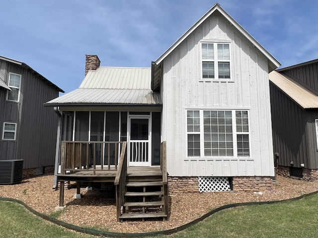 back of property with a sunroom and central AC