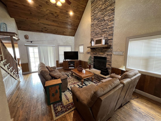 living room with high vaulted ceiling, wooden ceiling, ceiling fan, a fireplace, and hardwood / wood-style floors