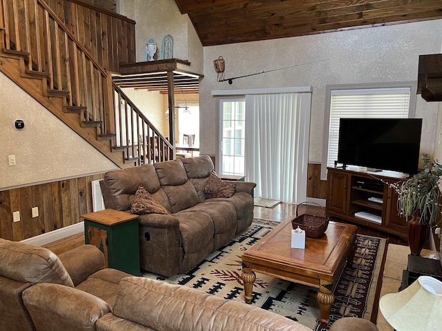 living room featuring lofted ceiling and wood walls