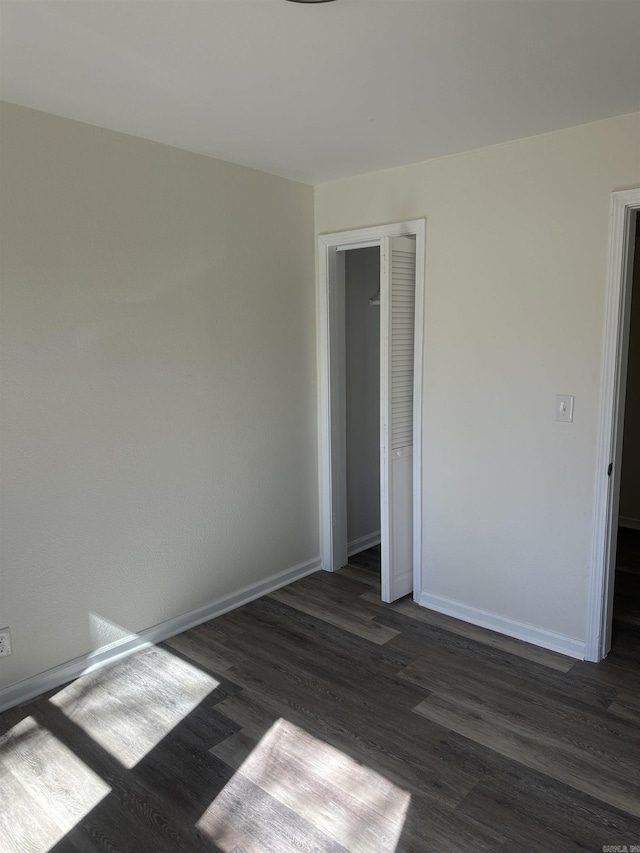 empty room with dark hardwood / wood-style flooring