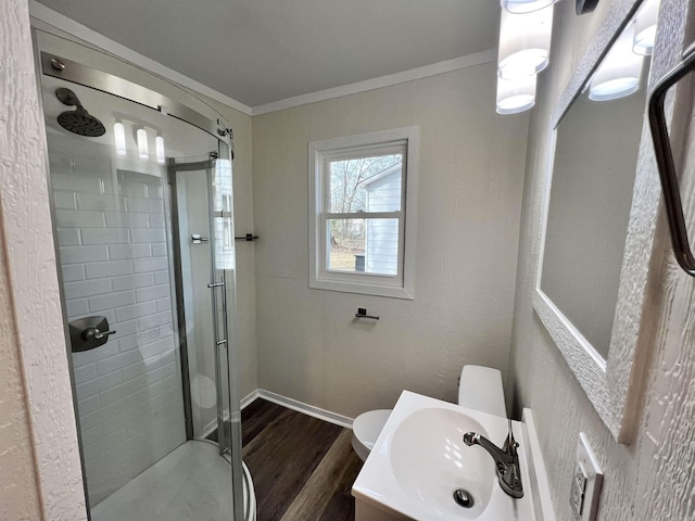 bathroom featuring toilet, an enclosed shower, wood-type flooring, ornamental molding, and vanity