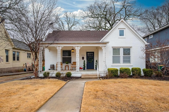 bungalow-style home featuring a porch and a front yard