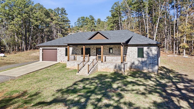 view of front of home with a garage, a front lawn, and covered porch