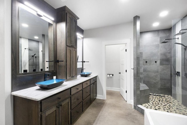 bathroom with vanity, concrete floors, and separate shower and tub