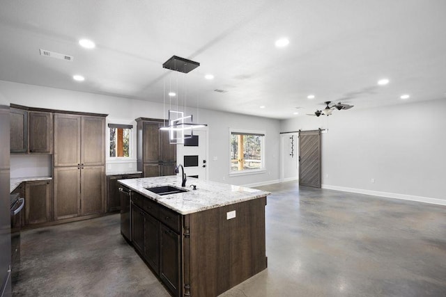 kitchen with sink, dishwasher, hanging light fixtures, an island with sink, and a barn door