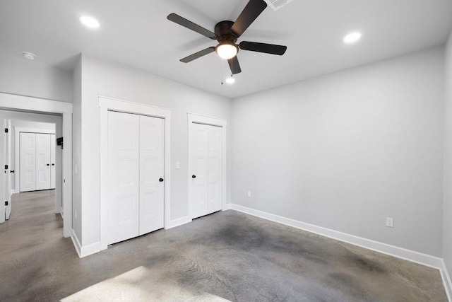 unfurnished bedroom featuring multiple closets and ceiling fan