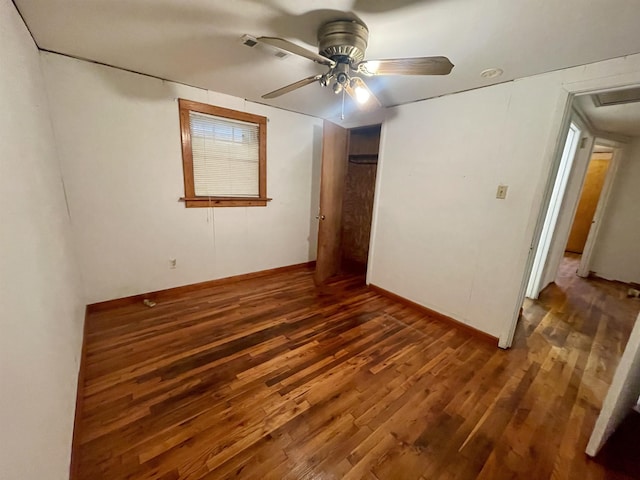 empty room with ceiling fan and dark hardwood / wood-style flooring