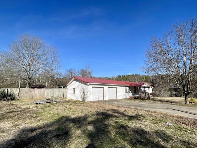 view of side of property featuring a garage and a yard