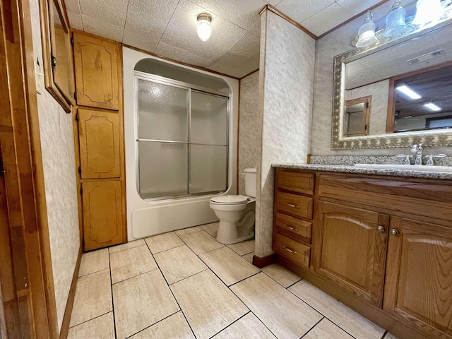 full bathroom featuring toilet, vanity, and shower / bath combination with glass door