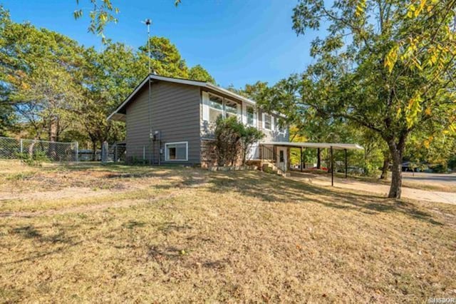 view of home's exterior featuring a carport and a yard