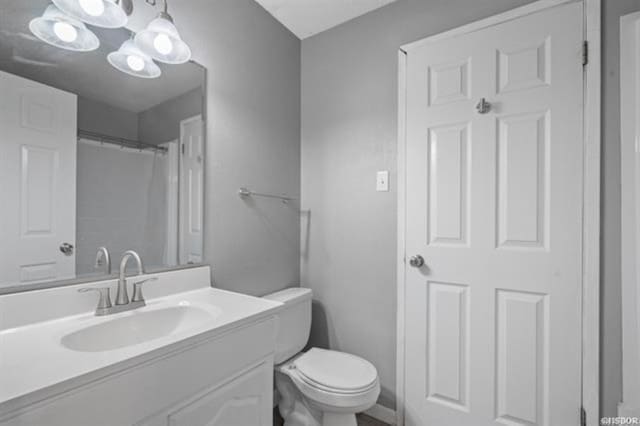 bathroom with vanity, walk in shower, and toilet