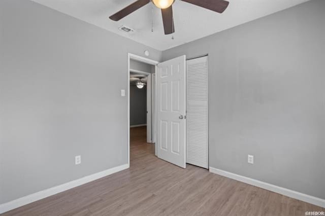 unfurnished bedroom featuring a closet, ceiling fan, and light wood-type flooring