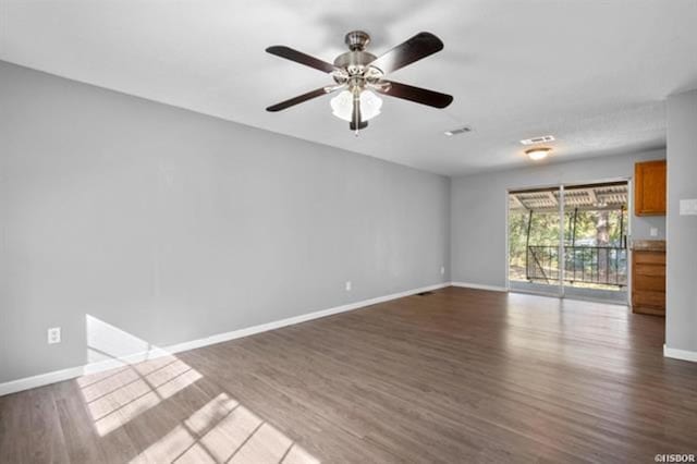 empty room with dark wood-type flooring and ceiling fan