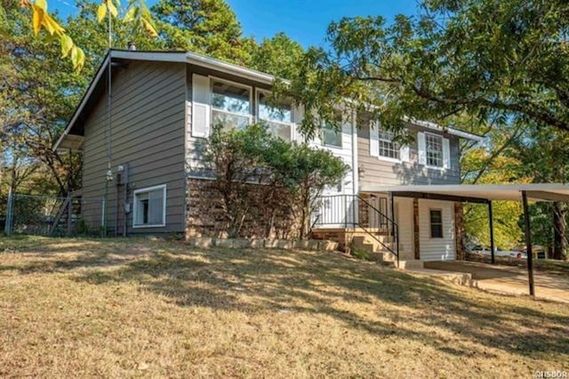 back of property featuring a carport and a lawn