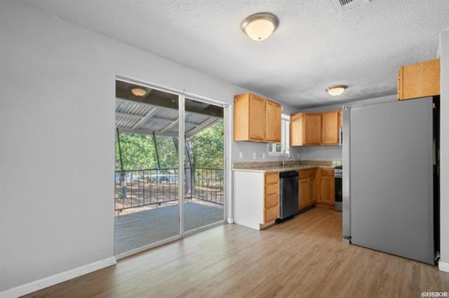 kitchen with sink, light hardwood / wood-style flooring, stainless steel appliances, and a textured ceiling